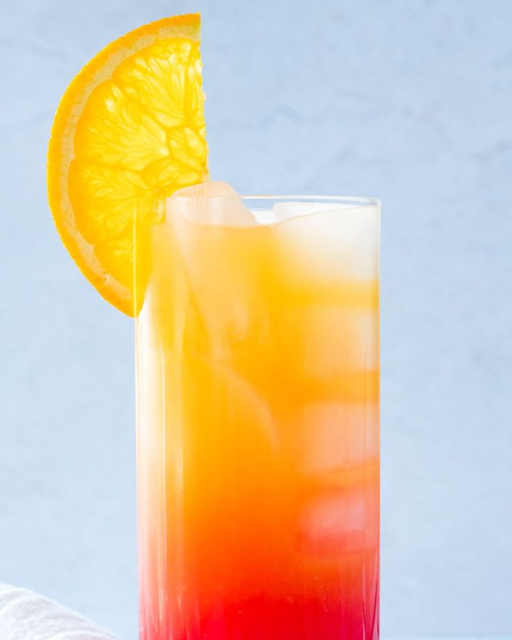 an orange and red drink sitting on top of a table