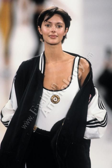 a woman is walking down the runway wearing a black and white outfit with an adidas logo on it