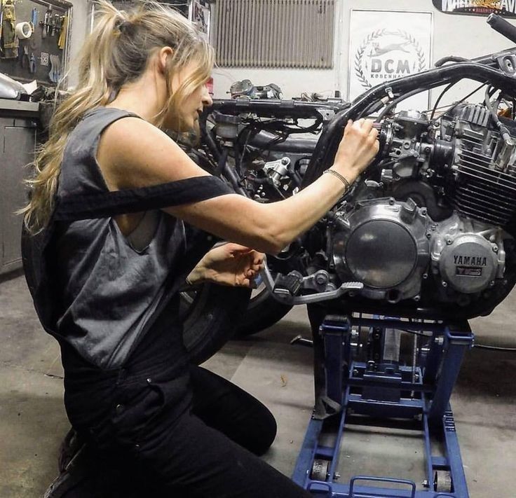 a woman working on an engine in a garage