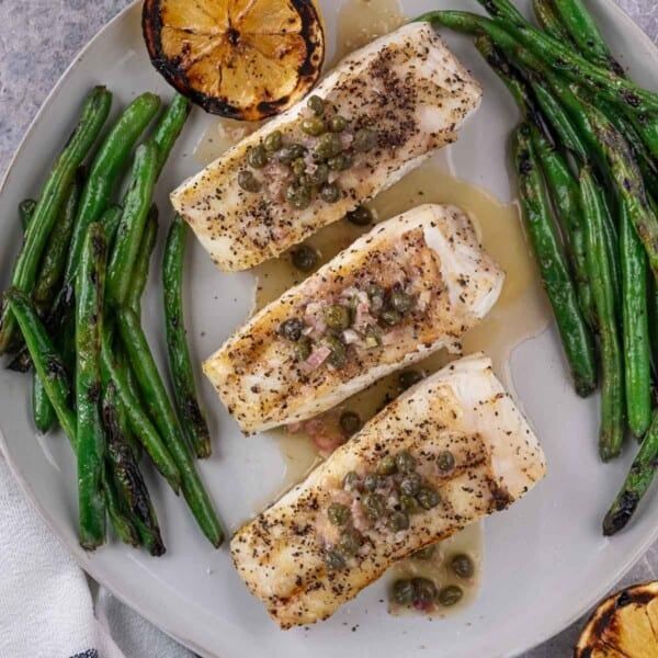 grilled fish and asparagus on a white plate