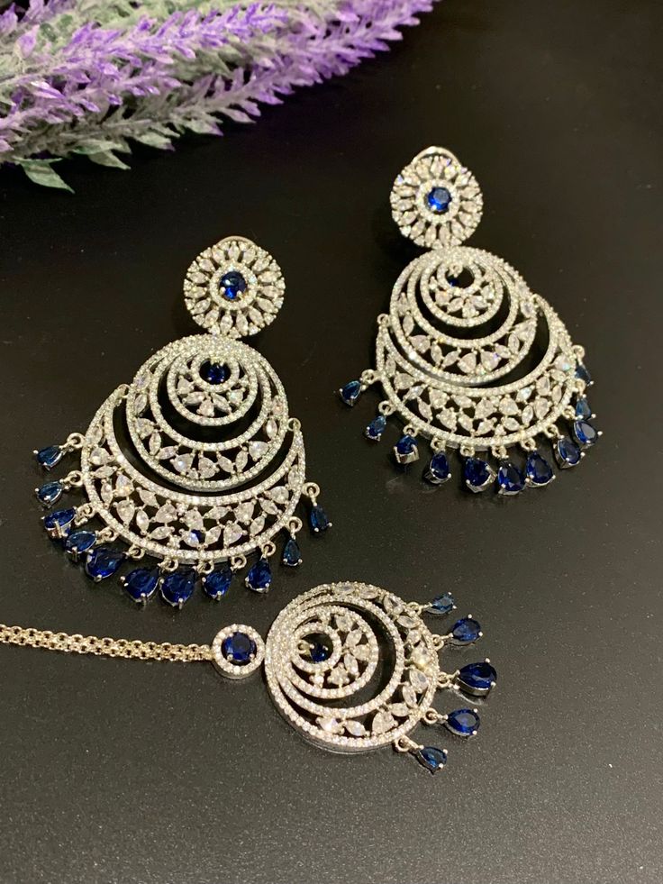 American diamond earring tikka set lovely in silver . Comes with a tikka. about 3 inch long and one and half in width. Tikka is about one inch long. Elegant Silver Hand Set Tikka, Elegant Silver Hand-set Tikka, Silver Chandbali-style Jewelry Sets With Elegant Design, Silver Diamond Earrings With Stone Work, Diwali Jewelry Sets With Matching Earrings, American Diamond Stone Work Drop Earrings, Dazzling Silver Chandbali Jewelry, Elegant Sterling Silver Chandbalis For Wedding, Traditional Silver Tikka With Matching Earrings