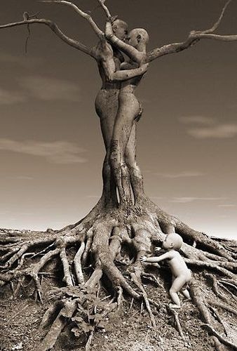 two people hugging each other in front of a tree with its roots exposed and the sky above