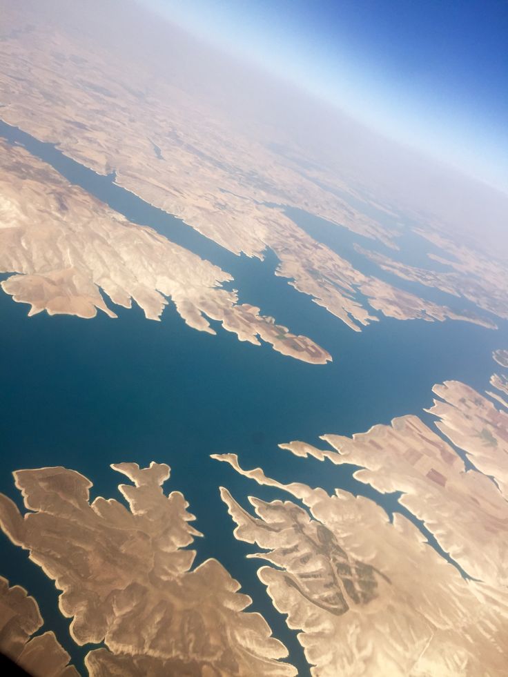 the view from an airplane looking down at land and water in the ocean below it