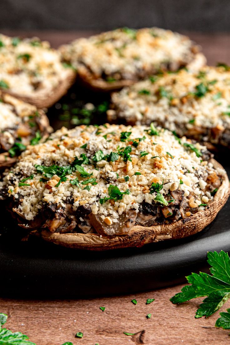 mushrooms with parmesan cheese and herbs on a black plate