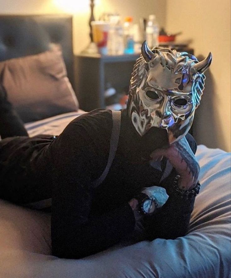 a person laying on a bed wearing a mask