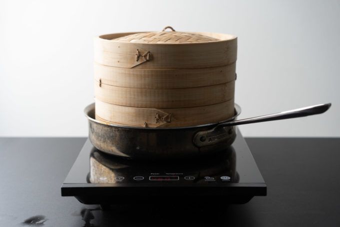 a stack of wooden bowls sitting on top of a black stove with a spoon in it