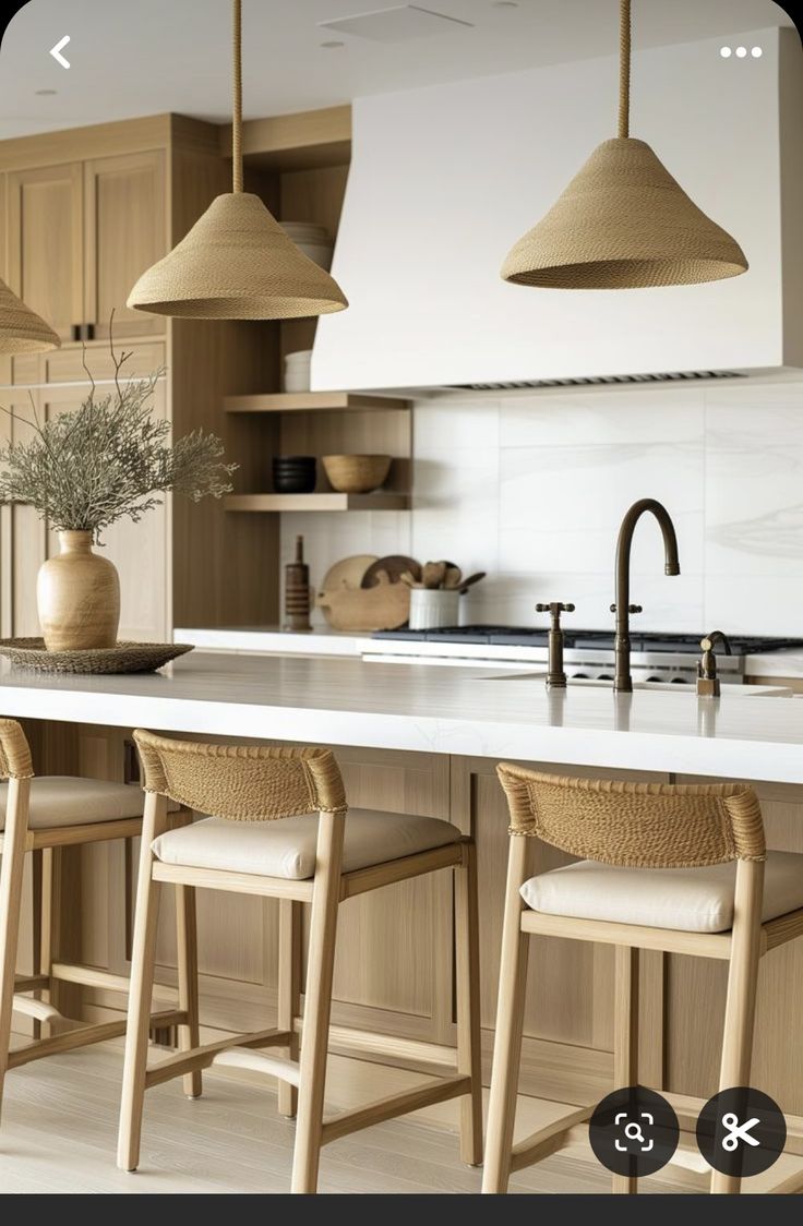 an image of a kitchen setting with stools and lights above the island countertop