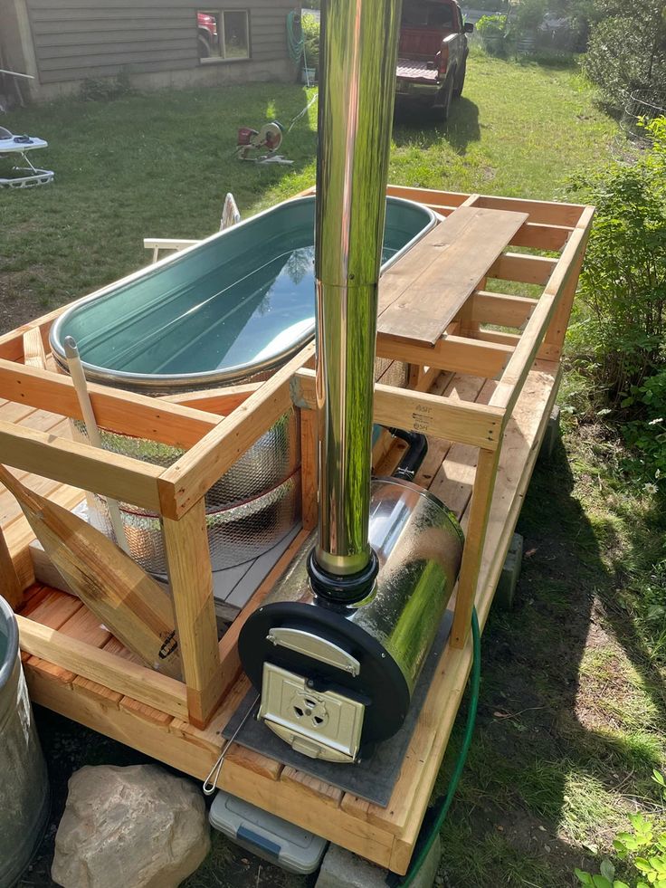 an outdoor hot tub is built into the side of a wooden deck and sits on top of a pallet