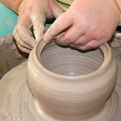 a person making a pot on a potter's wheel