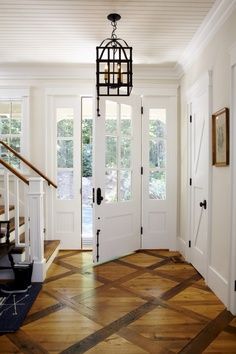 a foyer with wooden floors and white doors