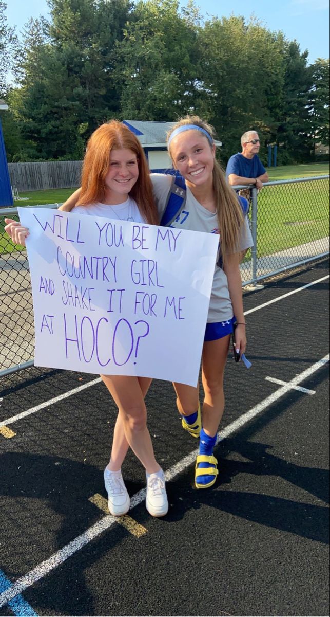 two girls holding a sign that says, will you be my country girl and save it for me at hoop?