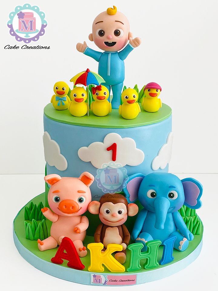 a birthday cake with an elephant, monkey and other animals on it's top