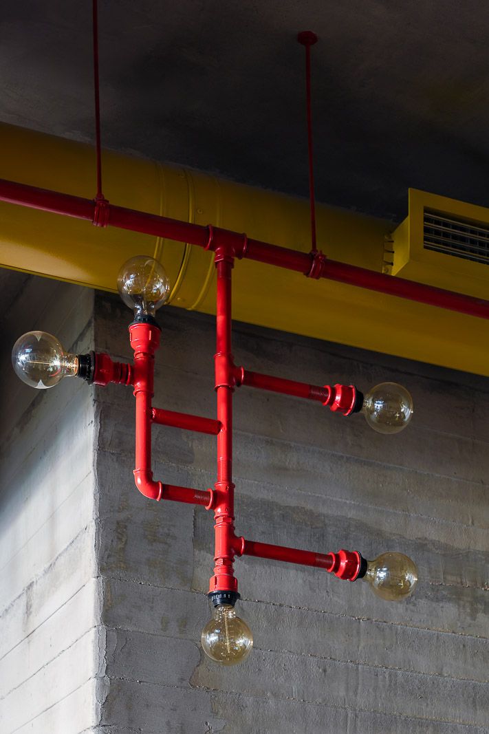 red pipes and light bulbs hang from the ceiling