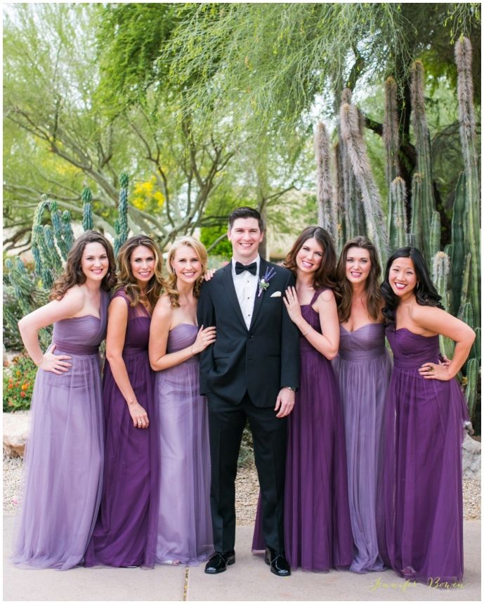 a group of young people standing next to each other in front of cacti