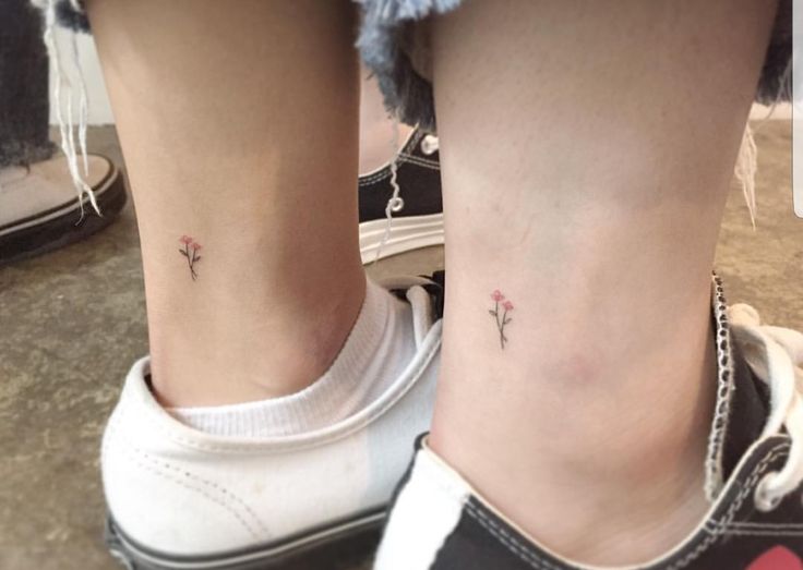 two small tattoos on the legs of people who are wearing white sneakers and black shoes