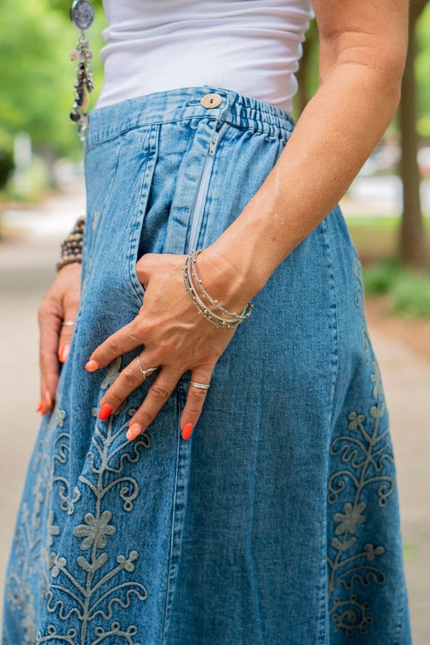 The Rachel Embroidered Skirt in Blue ♡ Product Highlights ♡ Our Rachel Embroidered Skirt in Blue is the perfect stylish and unique bottom to add to your closet, and or any on-trend bohemian style outfit! Accompanying a beautifully embroidered detail, a stretchy waistband for some give, a side zip closure, and conveniently placed side pockets, this skirt gives your look a sophisticated and stylish element. Make a statement with this Rachel Embroidered Skirt in Blue! ✁ Contents & Measurements ✁ Th Embroidered Flared Skirt For Summer, Casual Long Skirt With Floral Embroidery, Bohemian Denim Blue Bottoms For Summer, Blue Midi Denim Skirt For Summer, Blue Denim Midi Skirt For Summer, Bohemian Tiered Skirt For Spring, Bohemian Blue Denim Skirt For Spring, Casual Embroidered Relaxed Skirt, Casual Relaxed Embroidered Skirt