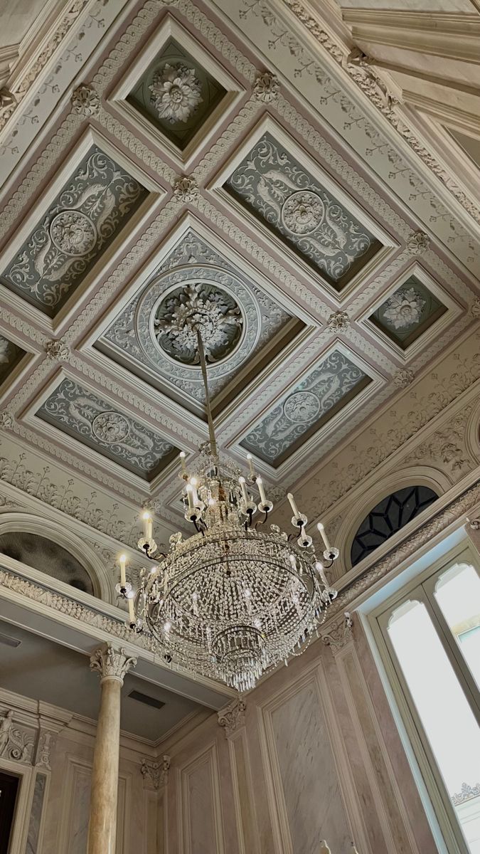 a chandelier hanging from the ceiling in a room with white walls and ceilings