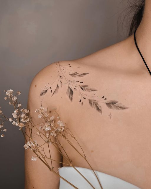 the back of a woman's shoulder with flowers and leaves painted on her chest