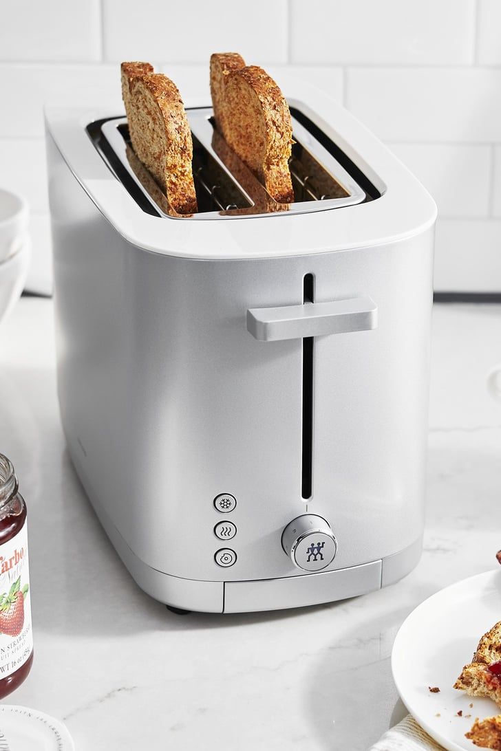 two slices of toaster sitting on top of a counter next to plates with food