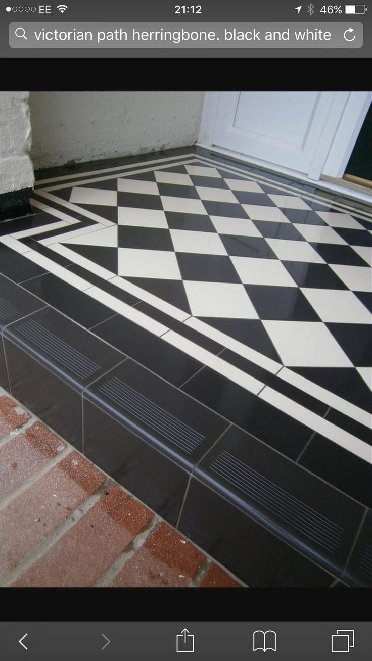 a black and white checkerboard floor in front of a door on a brick walkway