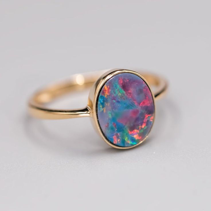 14K Yellow Gold Engagement Ring featuring an Oval Australian Doublet Opal. Free Domestic USPS First Class Shipping! Free One Year Limited Warranty! Free Gift Bag or Box with every order! Opal—the queen of gemstones, is one of the most beautiful and rarest gemstones on earth. Every piece of opals has its colors and patterns, which is perfect for designers to create unique engagement rings for someone extra special. We use 100% Natural & Ethically opal stones (NO synthetics or imitations) for our jewelry. ---------------------------------------------------------------ABOUT THIS PRODUCT14K Yellow Gold, Australian Doublet Opal, 1.15 ctMetal Color: GoldenOpal Color: Red, Yellow, Green & BlueRing Surface Measures: 11x9 MMRing Size: 7Occasion: Engagement/Birthday/Anniversary---------------------- Rarest Gemstones, Solid Opal Ring, Opal Promise Ring, Rings For Couples, Opal Birthstone, Australian Black Opal, Promise Rings For Couples, Yellow Gold Engagement Ring, Twisted Band