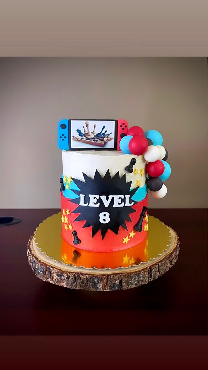 a birthday cake is decorated with balloons and an action figure on the top, which reads level 8