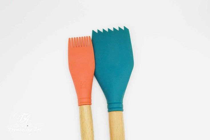 two colorful spatulas sitting next to each other