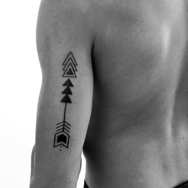 a black and white photo of a man's arm with an arrow tattoo on it