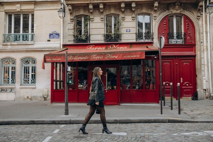 a woman walking down the street in front of a store