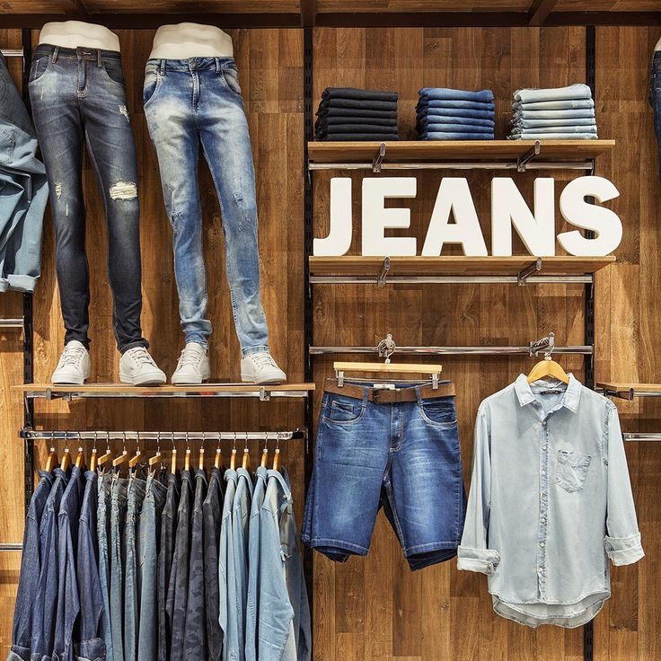 clothes and jeans are displayed on shelves in a clothing store, with the name jean's above them