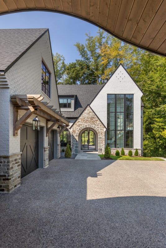 a large house with an attached garage and covered walkway leading up to the front door