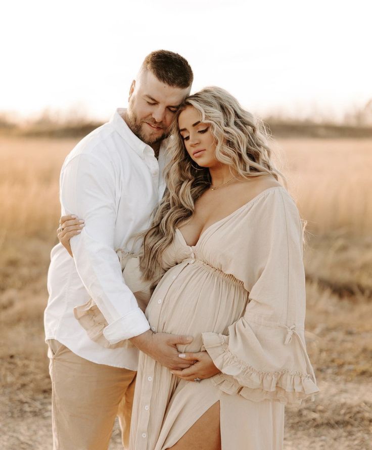 a pregnant woman and man standing next to each other