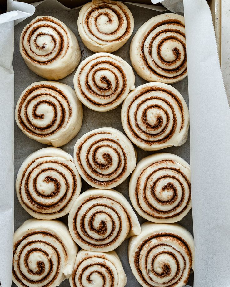 there are many cinnamon rolls on the baking sheet