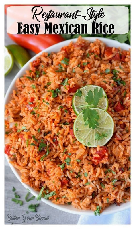 mexican rice in a white bowl with limes and cilantro on the side