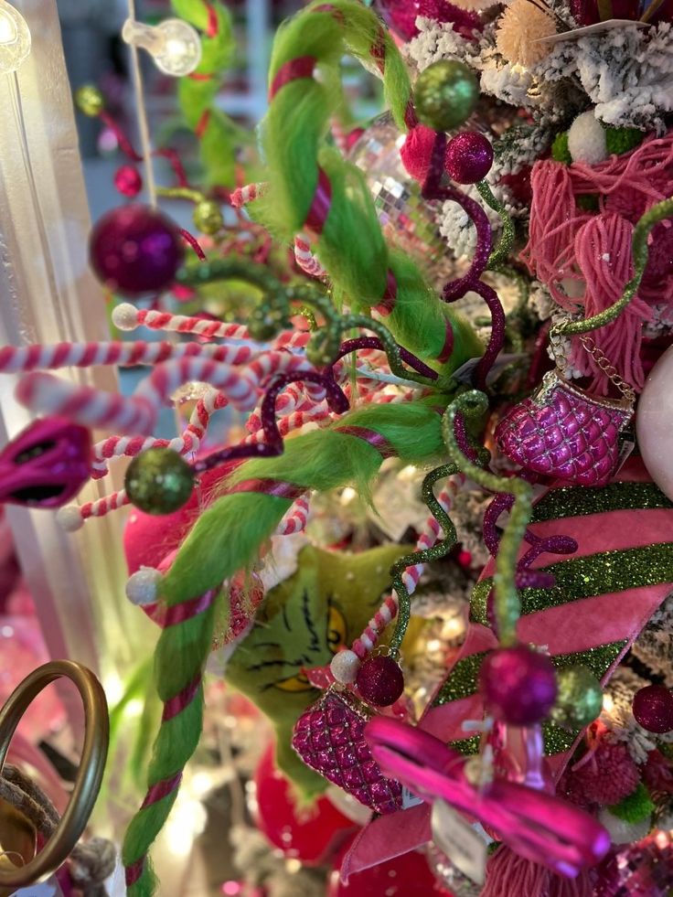 a christmas tree decorated with pink, green and gold ornaments