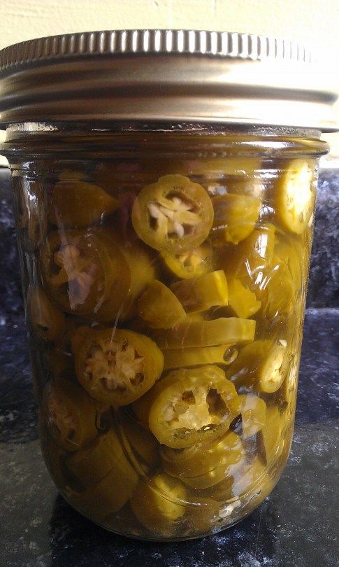 a jar filled with pickles sitting on top of a counter