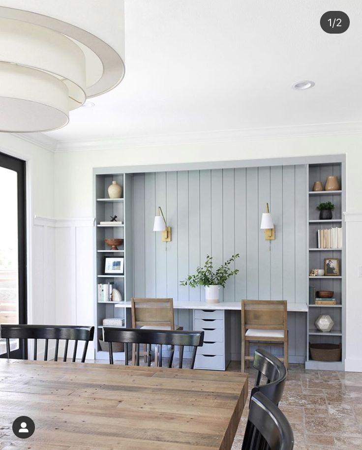 a dining room table with chairs and bookshelves