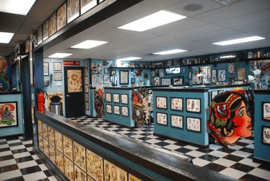 a checkered floor in a store with pictures on the wall and paintings on the walls