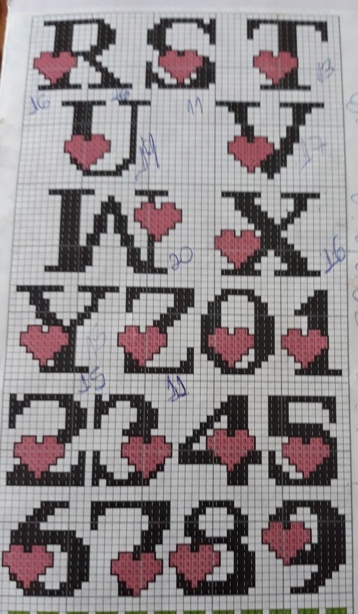 a cross - stitch pattern with hearts and letters in the middle, on top of a piece of paper