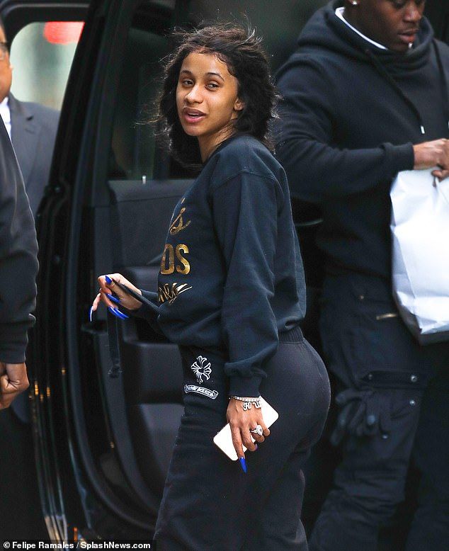 a woman in black sweatpants stepping out of a car with her hand on her hip