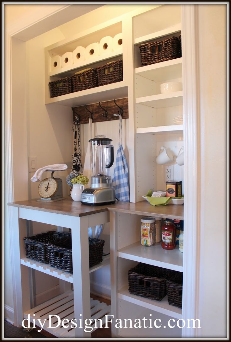 a kitchen with white shelves and baskets on the bottom shelf next to an open door