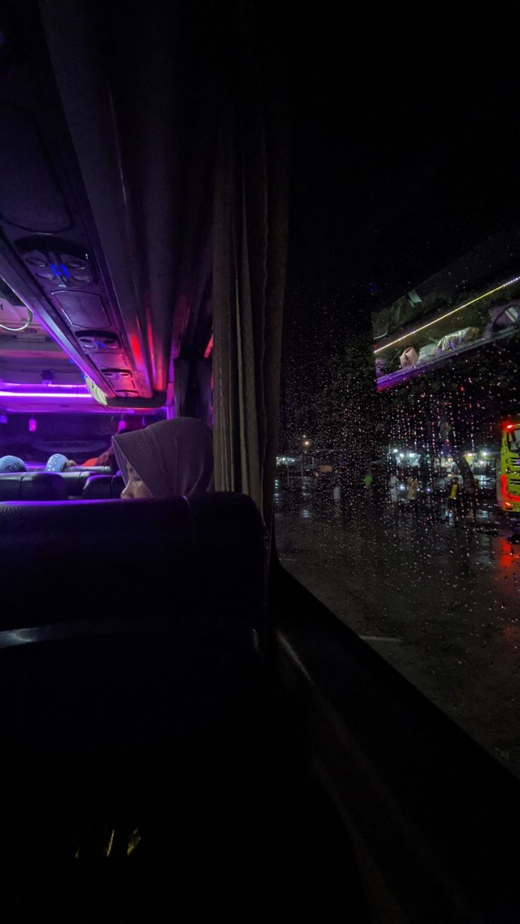 the inside of a bus at night with lights on