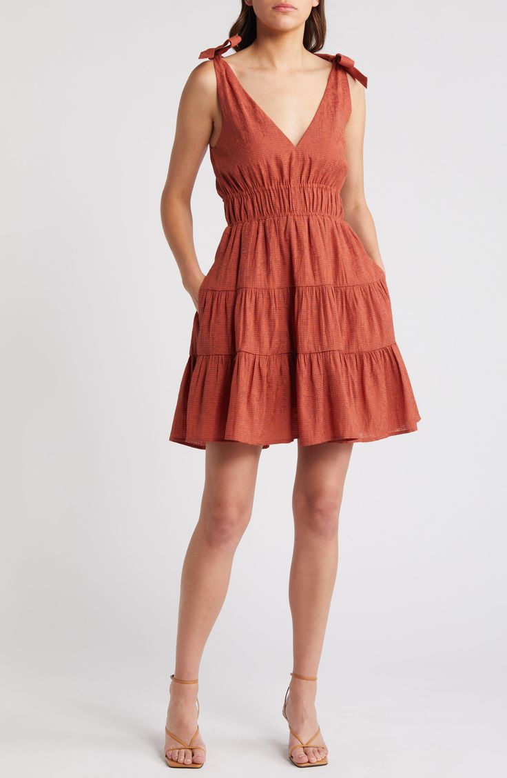 A tiered, ruffled skirt adds playful flounce to this smocked-waist minidress punctuated with ties at each shoulder. 35" length (size Medium) Slips on over head V-neck Side-seam pockets Lined 61% rayon, 27% polyester, 12% nylon Machine wash, line dry Imported Spring Tiered Sundress, Casual Lined Mini Dress, Sundress With Ruffles In Mini Length, Sundress Tiered Mini Dress With Ruffles, Casual Tiered Skirt Ruffle Dress With Ruffle Hem, Spring Dress With Smocked Bodice And Skirted Shape, Mini Length Tiered Sundress With Ruffle Hem, Sundress With Ruffles And Mini Length, Smocked Bodice Fit And Flare Mini Dress