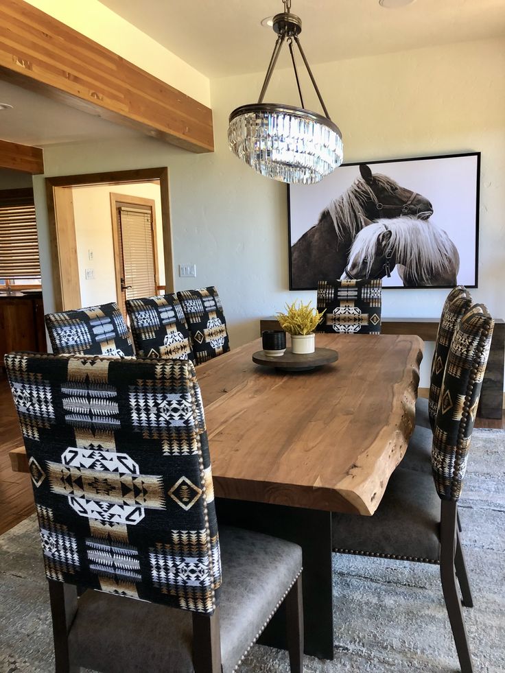 a dining room table with chairs and a chandelier hanging from it's ceiling