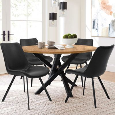 a dining table with four chairs and a bowl of fruit on it