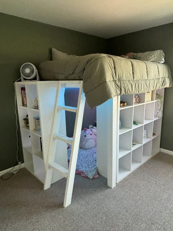 there is a loft bed with a ladder to the top and bookshelf below