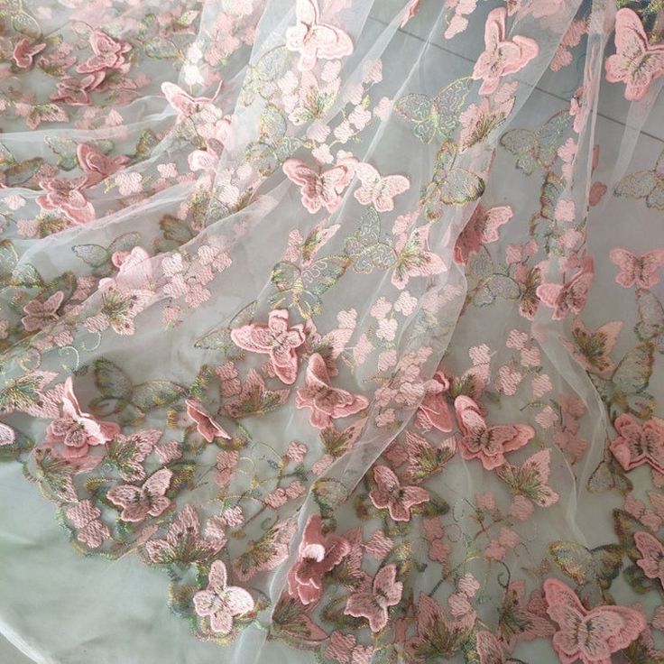 pink flowers and butterflies embroidered on sheer mesh fabric, with lace edge in the center