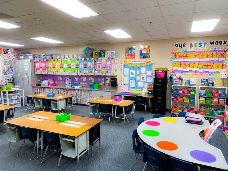 an empty classroom with desks and chairs in front of the bookshelves filled with children's artwork