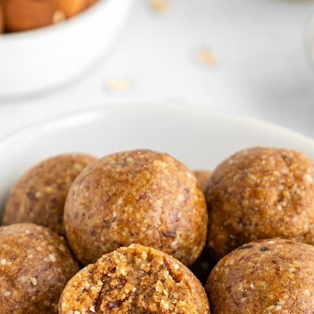 a white bowl filled with muffins on top of a table next to other food items