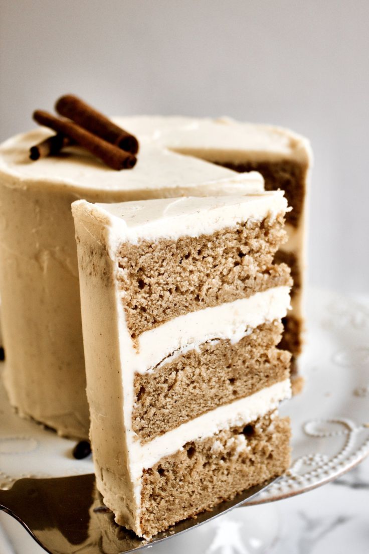 a piece of cake with white frosting and cinnamon sticks on top